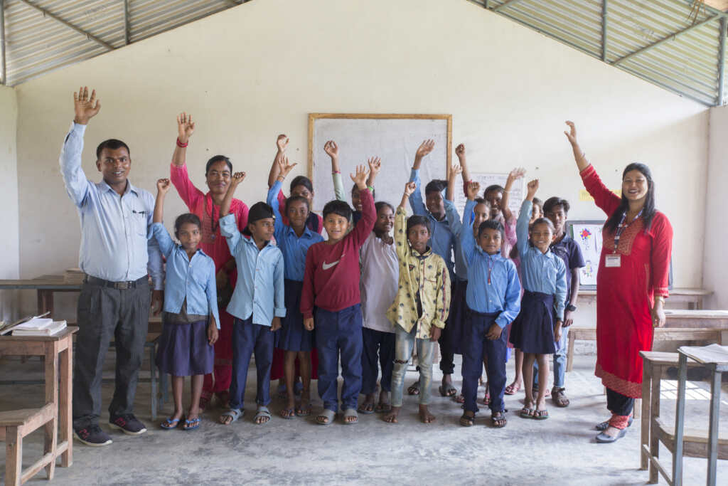 Rekha and students from Nepal raising their hands and smiling